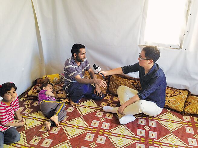 杨明交（右）于2014年在叙利亚採访带着妻小逃至黎巴嫩难民营的穆萨。（三民书局提供）