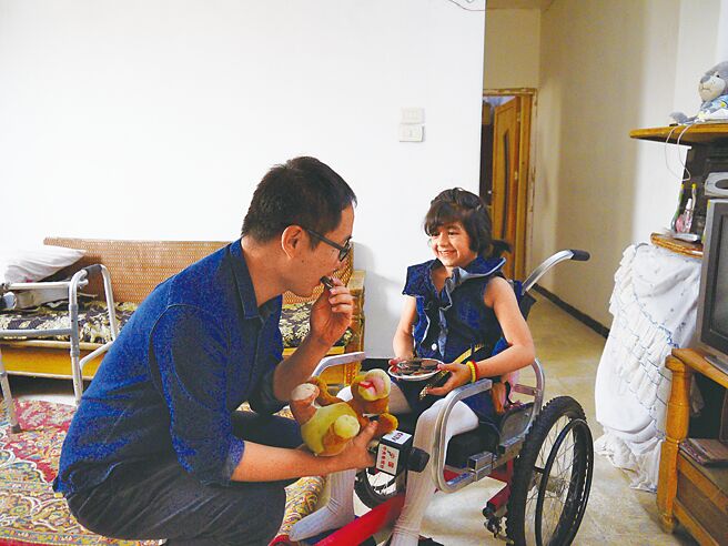 杨明交（左）于叙利亚採访因炸弹受伤的女孩哈宰勒，女孩送的布老虎至今陪伴着杨明交。（三民书局提供）