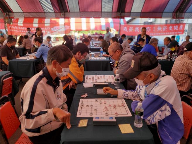 棋士們專心鬥智，有人提早準備手勢。（周麗蘭攝）