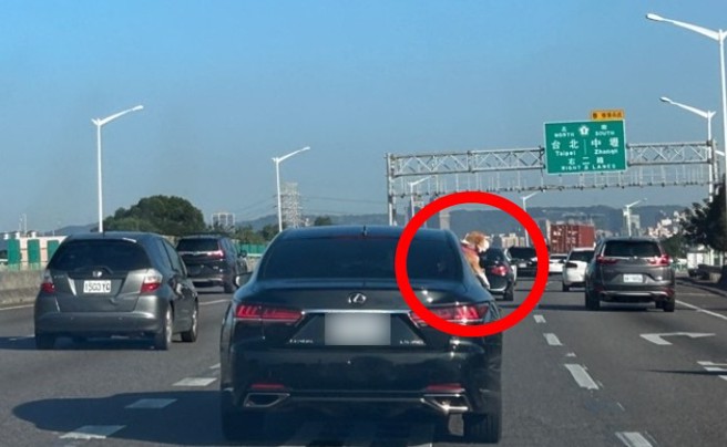 網友在國道上發現前車後座，有狗狗頭腳伸出車窗外。（翻攝爆料公社）
