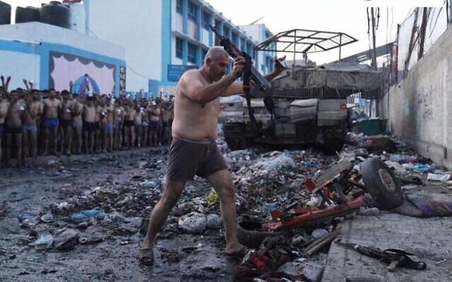 哈玛斯武装份子高举武器缴枪投降。(图/X)