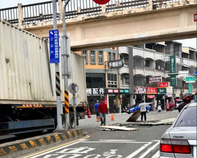 拖板车载货柜屋，因未超过高度，撞击天桥下方，导致屋顶铁片散落一地。（翻摄爆料公社）