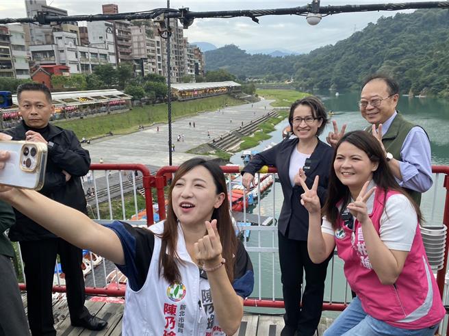 萧美琴11日傍晚在曾柏瑜、市议员陈永福及陈乃瑜陪同下漫步碧潭吊桥，体验碧潭风光，4人还在吊桥上玩起自拍。（高钧麟摄）