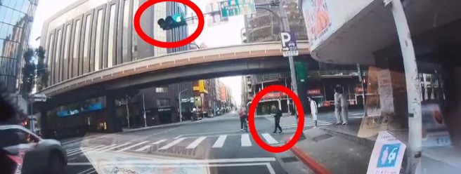 黑衣男子闯红灯过马路，边跳舞还比中指。（翻摄爆料公社）