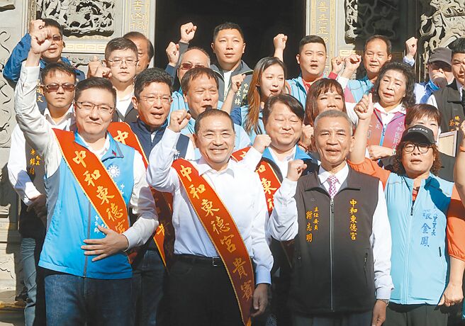 国民党总统参选人侯友宜（中）10日至中和东德宫参拜，侯友宜与支持民眾高喊当选，左为国民党立委参选人张智伦。（陈君玮摄）