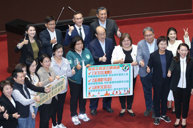 立法院12日院会三读通过「最低工资法草案」，民进党立委在党团总召柯建铭（前排中）的带领下于议场内合影留念。（姚志平摄）