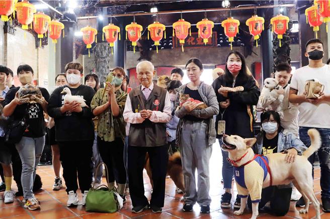 城隍廟董事長賴永川帶領主人及寵物們誠心向綏靖侯城隍尊神參拜，祈求「親子」平安健康。（呂妍庭攝）