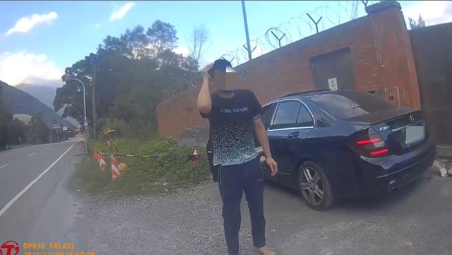 驾驶宾士车男子衝撞警车，下车后摸着头说：自己睡着了。（翻摄画面）