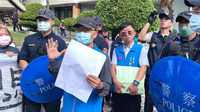 台東縣政府參議辛進祥（左三）、農業處長許家豪（右四）在警力戒護下出面接受連署書，引發在場居民質疑受藐視，揚言衝入縣府，場面火爆。（蕭嘉蕙攝）