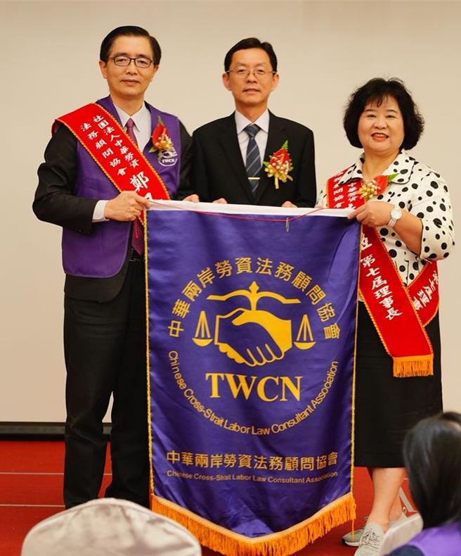 在高市府社会局专员兼股长王同选（中）监交下，新任第七届理事长洪仙姬（右），从第六届理事长郑又腆（左）手中接过锦旗。（柯宗纬翻摄）