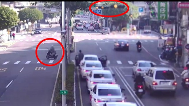 阮男騎機車等到邊燈才騎走，不時還回頭嗆聲。（翻攝畫面）