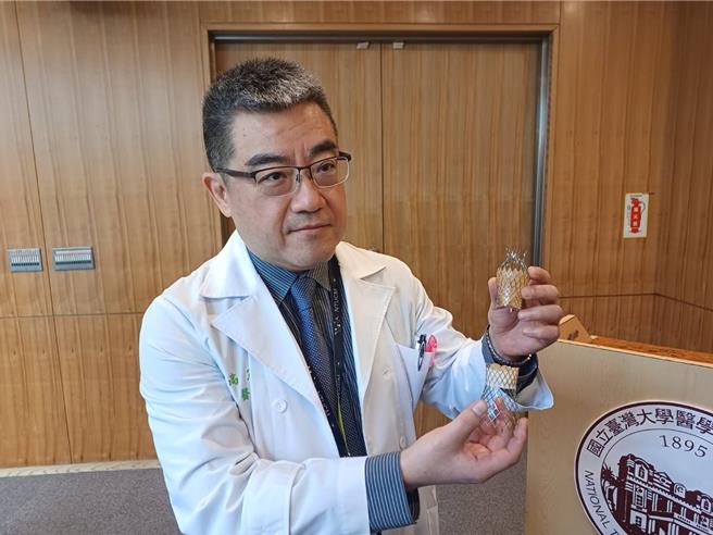 台大醫院心血管中心主任高憲立展示上下腔靜脈支架瓣膜。（王家瑜攝）