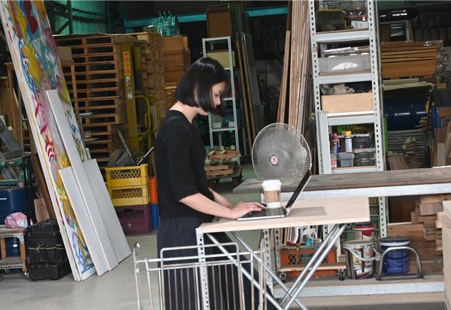 廢物救星主持人楊大廣把廢棄木材與回收品變成桌子（見圖），展示人員在桌子上操作電腦。（林瑞益攝）