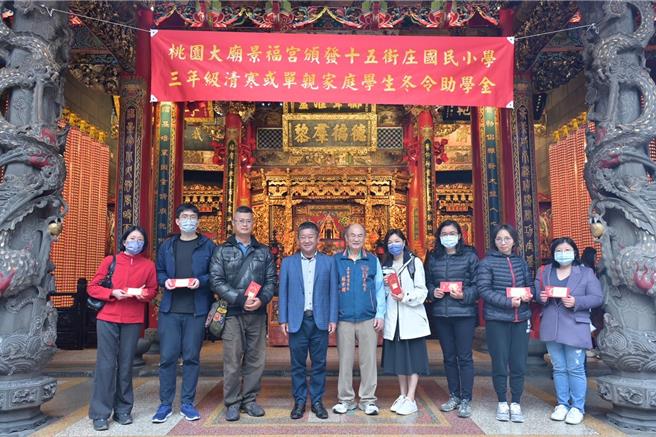 桃园大庙景福宫今由主委简征潭代表颁助学金给236学子。(庙方提供／蔡依珍桃园传真)