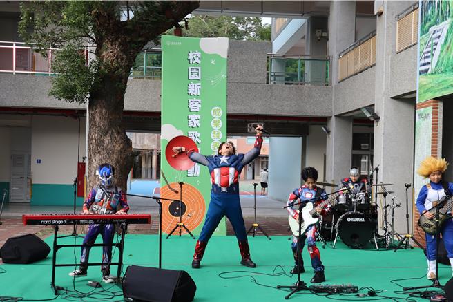 校園新客家歌運動13日在芎林國小舉辦發表會，壓軸出場的羅文裕（左二）與小學生一同嗨唱搖滾風格的創作曲。（邱立雅攝）