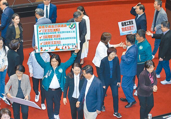 立法院12日院會三讀通過《最低工資法》，各黨立委輪流在議場內合影留念。（姚志平攝）