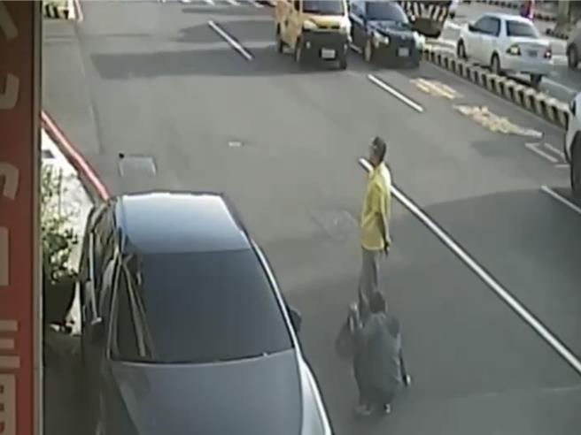 台中市北區中清路一段438號前日前出現螺絲釘散落一地，1名熱心民眾冒險蹲路中撿拾，另1名則站在一旁協助擋車。（民眾提供／潘虹恩台中傳真）