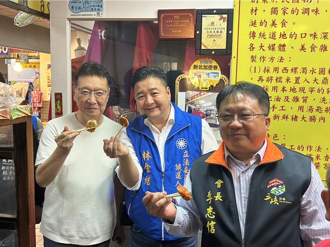 2023年12月13日新北市／趙少康（後）也在林金結（前）的介紹下品嘗金牛角麵包、大腸圈等在地小吃。（劉瑋晴攝）