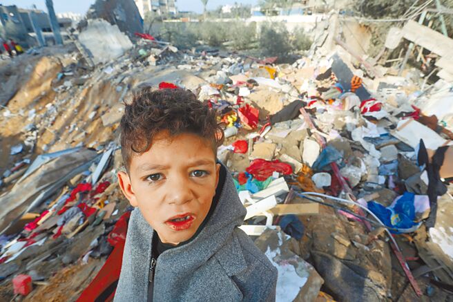根據聯合國衛星照片分析，迦薩基礎設施已有18％遭戰爭摧毀。圖為一名男孩站在迦薩城市廢墟上。（新華社）