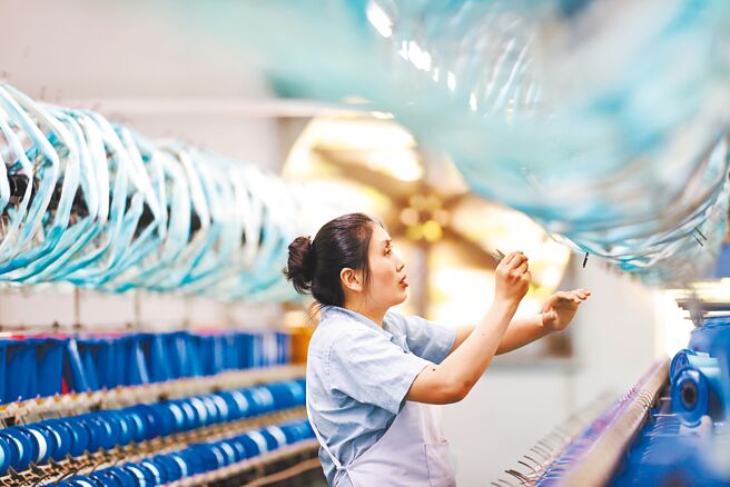 中共中央財辦副主任韓文秀表示，明年經濟工作不能脫離實際、急於求成。圖為重慶市黔江區絲綢紡織企業廠房作業情景。（新華社）