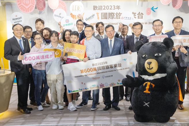 「第600万名来台国际旅客欢迎仪式」15日在桃园机场举行，行政院副院长郑文灿（右四）、交通部长王国材（右三）及观光署长周永晖（左一）等人与来自新加坡的幸运儿陈先生（中）一家合影留念。（范扬光摄）