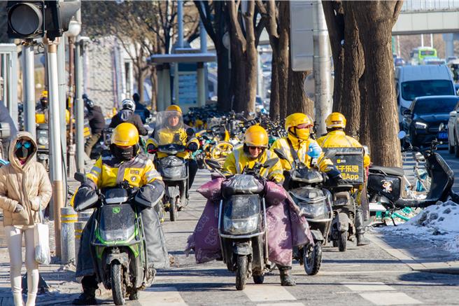 北京一波强降雪结束后进一步降温，16日最低下探-16℃，路上人潮减少，但低温商机仍让外卖骑手穿梭不断。（吴泓勋摄）