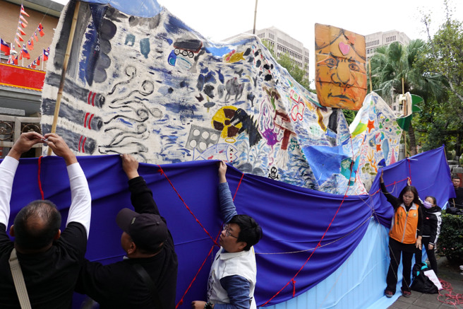 台湾蛮野心足生态协会、台湾健康空气行动联盟等团体16日在立法院外举行「2023反空污、抗暖化集会活动」，要求政府逐步汰除煤、油、气，加速摆脱化石燃料。过程中，行为艺术家带领民眾用布幔包捆立法院外墙，讽刺代议政治最高机构已消失？国会成为气候公民跨不过去的权力高墙。（姚志平摄）