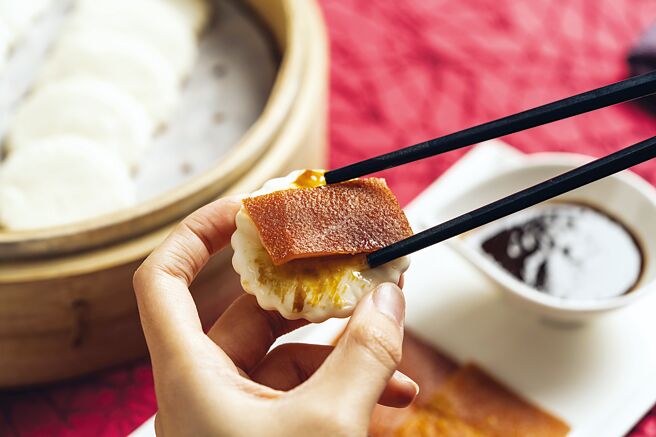 享用台北W饭店〈鸿运脆皮乳猪〉时，可搭配特制荷叶饼皮，与融合港式海鲜酱、蚝油及多种香料熬制的乳猪酱。图／台北W饭店