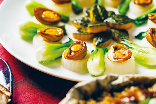 〈八头原只鲍鱼百花玉环盅〉是以老母鸡、金华火腿、猪后腿赤肉与蚝油熬制的高汤，慢火烹煮出鲍鱼，搭配黄瓜镶百花呈现。图／台北W饭店