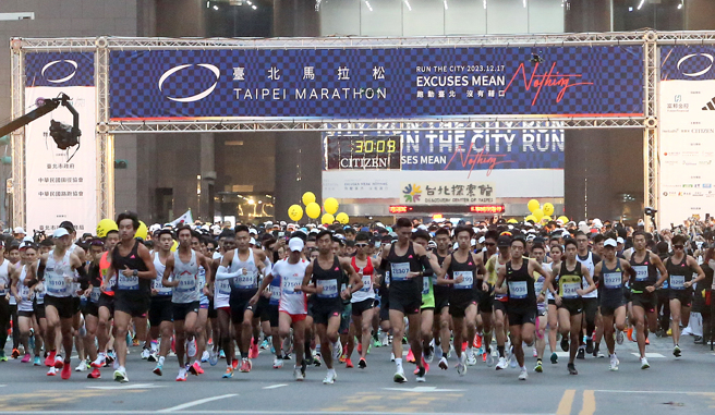 「2023台北馬拉松」17日在台北市政府前廣場登場，今年賽事匯集國內外2.8萬名長跑健將參賽，比賽時間一到大家賣力奔向終點。（趙雙傑攝）