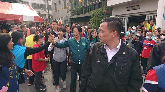 民进党总统候选人赖清德（绿色外套击掌者）17日在台南市连续参拜6间庙，进场时受到信徒欢迎。（程炳璋摄）