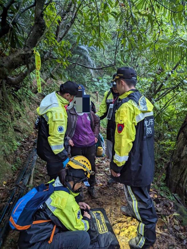 婦人滑落山坡，被消防隊員救起。（翻攝畫面）