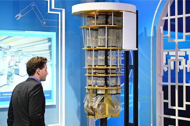 圖為一名民眾在上海進博會中國館觀看可編程量子計算機系統－祖沖之號模型。 （圖／中新社）