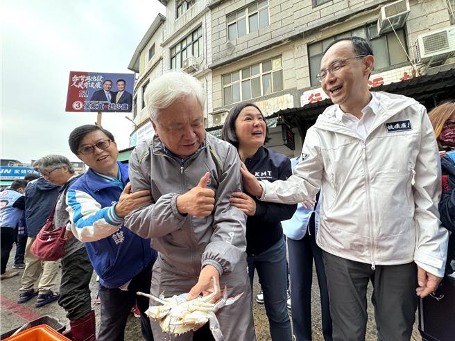 国民党主席朱立伦(右一)今日飞抵金门与立委参选人陈玉珍(右二)合体扫街，途中巧遇金厦大桥公投推手陈沧江(左二)趁机向他拉票，让这位前民进党议员只能尷尬比讚迴避说：「我只是来买螃蟹的」！（于家麒摄）