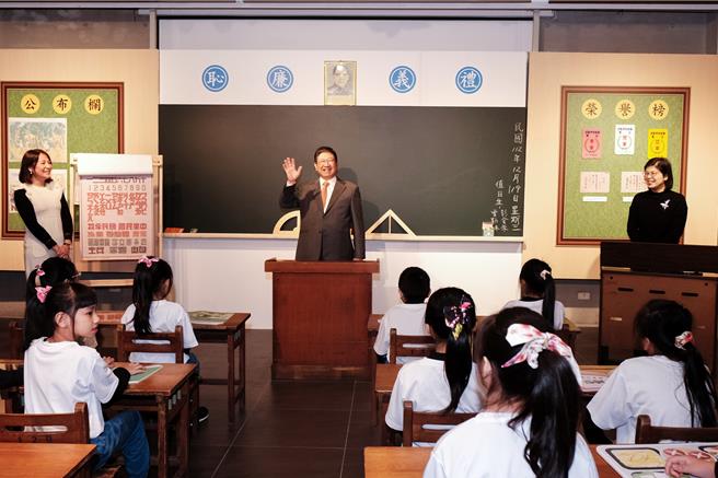 新竹县史馆19日「上课钟响 - 新竹县日治创校百年小学主题展」，还回早年教室挂国父孙中山遗像和「礼义廉耻」校训，县长杨文科（中）扮校长。（罗浚滨摄）