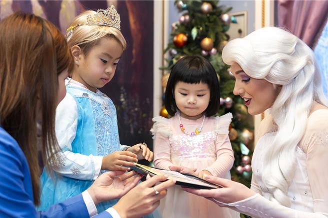 來自香港現年4歲的林心玥（左二）與迪士尼樂園的「艾莎公主」見面。（香港迪士尼提供／吳娮翎台北傳真）