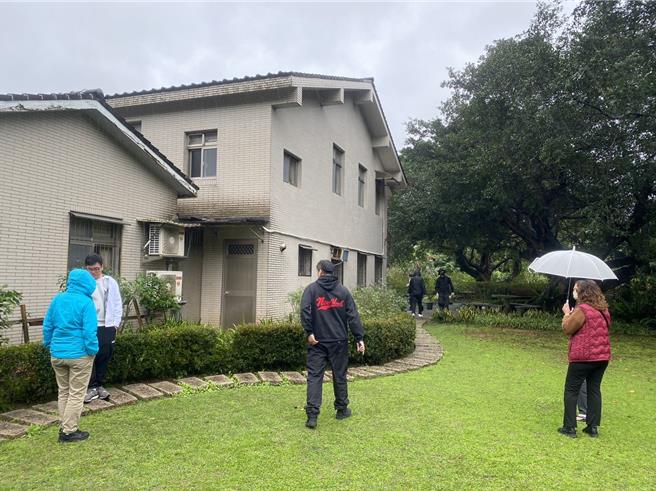 游客从屋前逛到屋后，逛累了便坐在高耸参天大榕树下的长凳歇息。（高钧麟摄）