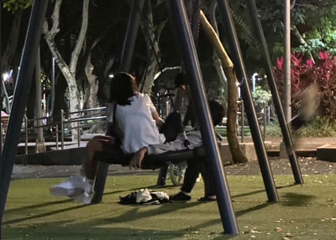 一對年輕男女在公園內一起玩盪鞦韆。（翻攝爆廢公社二館）