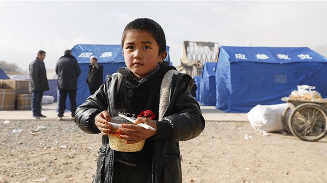 大陸糧儲局稱地震災區米麵油供應充足，價格平穩。圖為19日在甘肅臨夏積石山縣大河家鎮大河村安置點，小朋友領取愛心牛肉麵。（新華社）