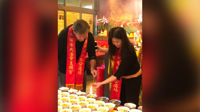 方雋哲在道場工作人員協助下點亮七星燈。（圖片來源：姜太公到場提供）

