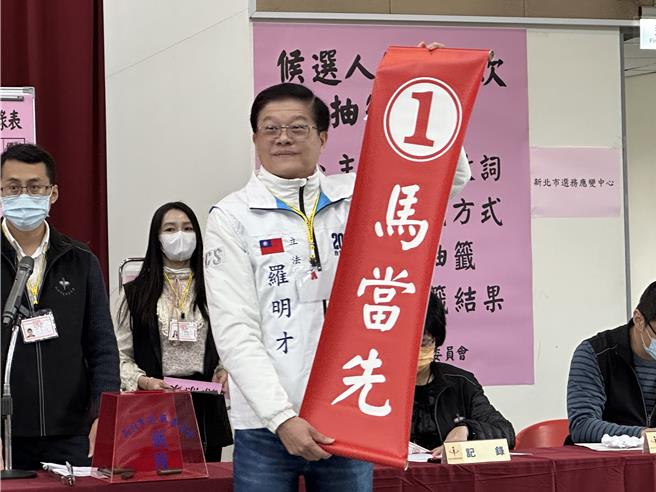 十一選區羅明才抽到籤王1號，羅早已備妥「1馬當先」條幅，喊出「大新店文山區1定成功！」（高鈞麟攝）