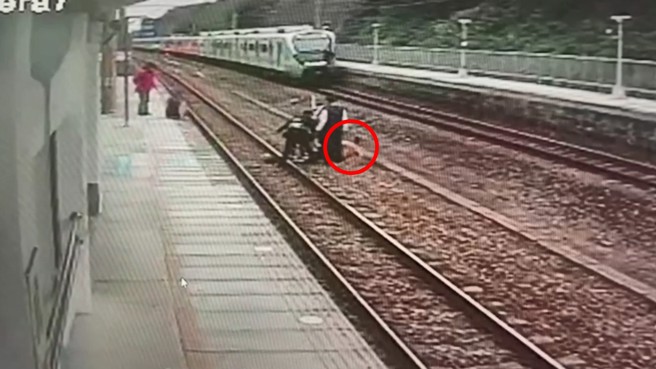 男子硬闯铁道遭站务人员驱离，男子强力挣扎连衣服都脱了。（翻摄画面）