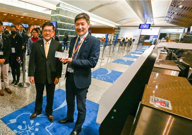 机场公司董事长杨伟甫（左） ）、总经理范孝伦（右），现场体验自助行李托运机臺。（陈麒全摄）
