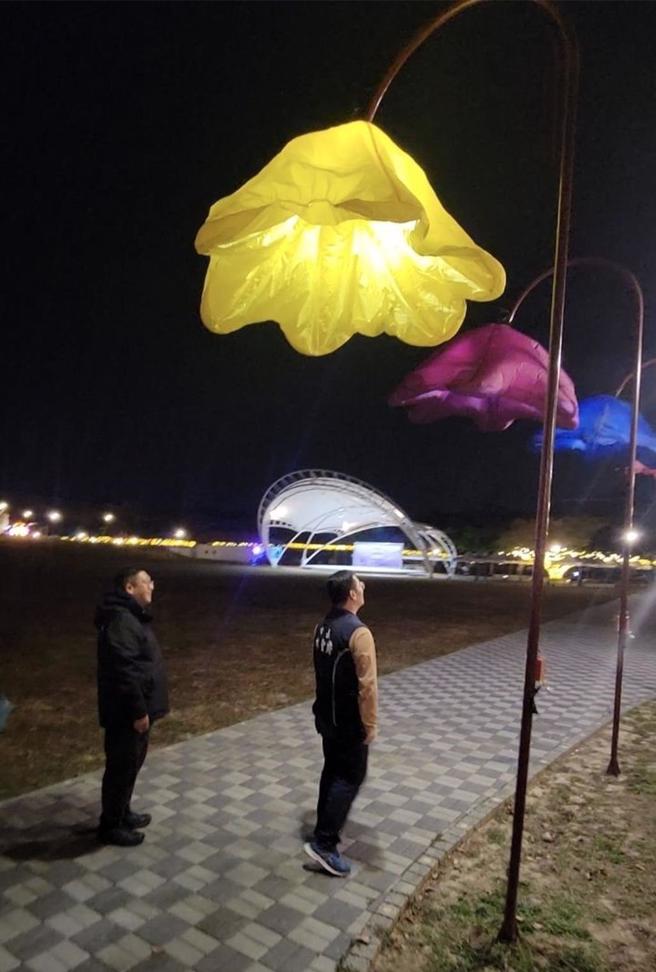 膨鼠森林公園還有一座高4公尺的花朵燈籠，只要人一接近對它喊「開花」，花朵燈籠就會打開，然後再闔上，市長林聖爵（右）親自試燈。（斗六市公所提供）