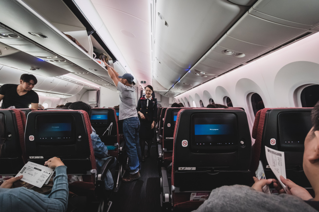 随身行李置入机舱座位上方的行李柜时，应把开口朝柜内放置。（示意图／Shutterstock）