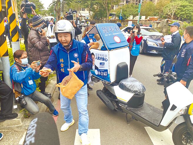 國民黨新北市十選區立委候選人林金結20日赴新北市選委會抽選舉號次，林別出心裁，騎著外送機車到場，分送三峽名產「金牛角麵包」給在場人員。（高鈞麟攝）