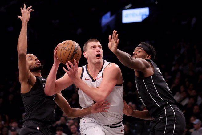 约基奇突破两名篮网球员包夹强行上篮。(路透)