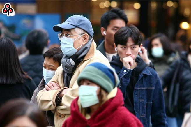 氣象署持續發布低溫特報，台北街頭民眾穿上禦寒物出門。（鄧博仁攝）