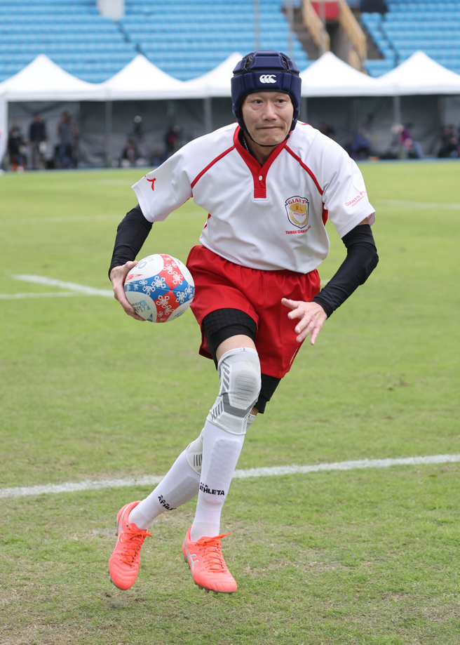 元坤盃大專橄欖球邀請賽創辦人杜元坤，脫下西裝換上球衣上場踢球，專注的眼神如同讓球迷感受到對橄欖球運動的熱愛。(元坤運動文創提供)