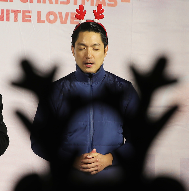 台北市长蒋万安23日出席2023台北耶诞爱无限健走报佳音活动，他在台上闭目接受牧师们为他祷告祈福。（季志翔摄）